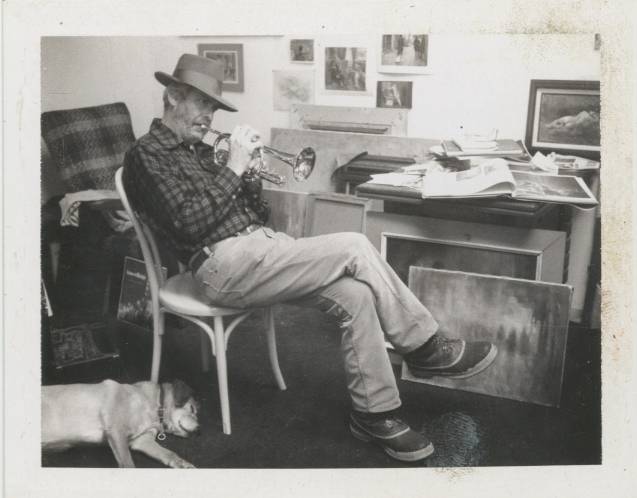 man playing trumpet sitting on chair